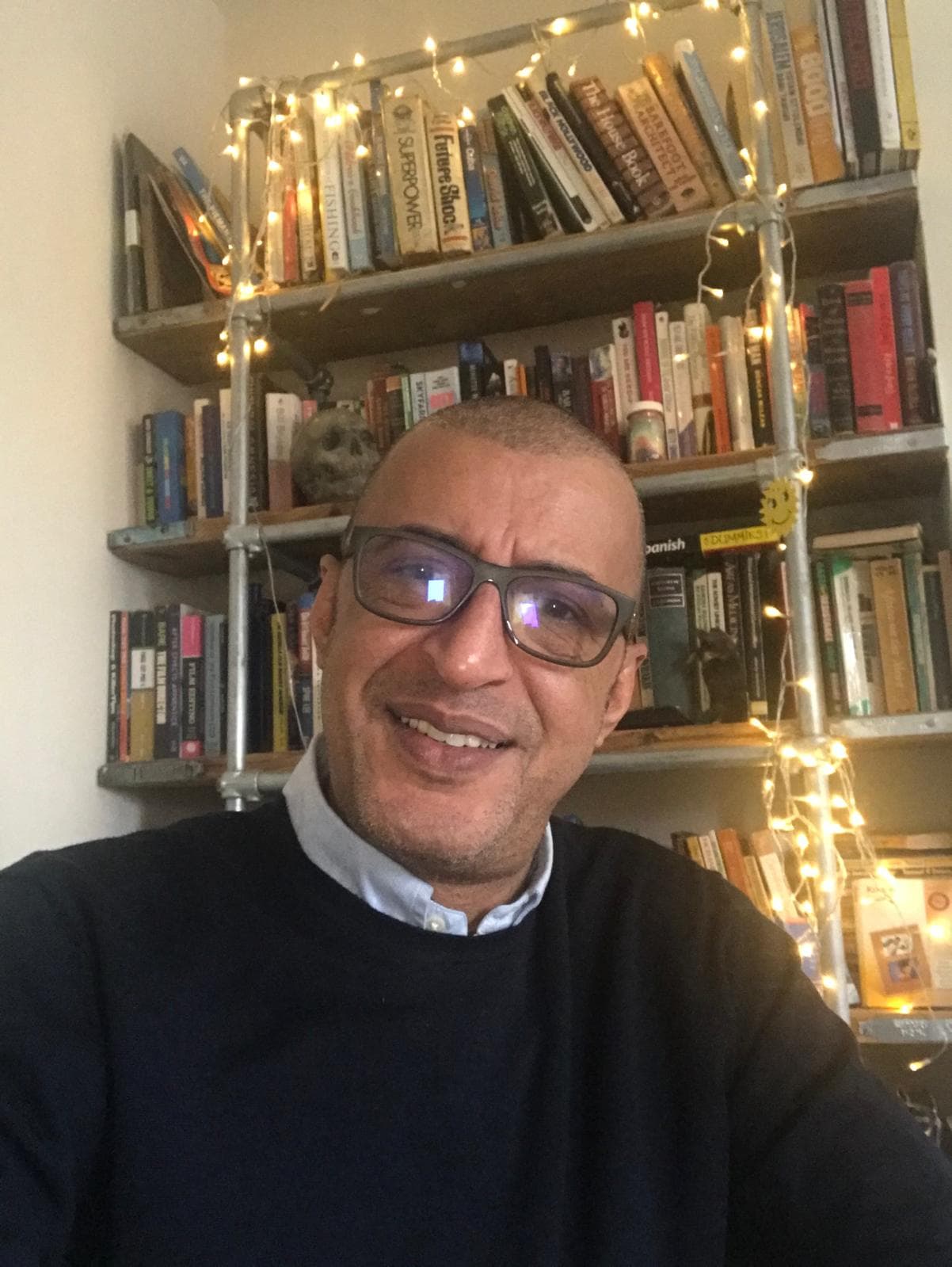 Kimaathi smiling in front of bookshelves